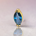 Instinct gold titanium labret with internal thread and marquise-cut blue gemstone.