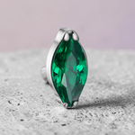 Instinct silver titanium labret with internal thread and a single green marquise cut gemstone.
