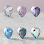 Instinct silver titanium labret piercing with teardrop-shaped cubic zirconia in clear, pink, purple, blue, mystic, and aurora borealis.