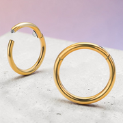 Instinct gold titanium clicker hoop earring with a small gem accent. Hinged closure for easy wear.
