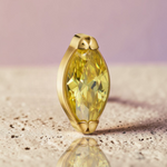 Instinct gold titanium labret piercing with internal threading and a marquise-cut yellow gemstone.