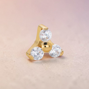 Instinct gold labret piercing with internal threading, featuring a trinity design with three clear cubic zirconia stones and a central gold bead.
