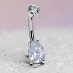 Instinct silver titanium belly button ring with clear round and teardrop cubic zirconia stones.