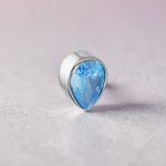 Instinct silver titanium labret with a blue teardrop-shaped crystal, internal thread.