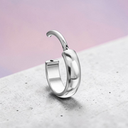 Instinct thick, round titanium hoop earrings in silver, gold, and black finishes.