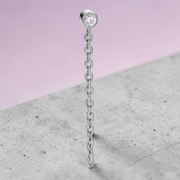 Instinct silver and gold titanium labret piercing with internal threading and a chain with a clear gem.